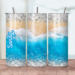 Sandy beach and water tumbler shown on all sides, featuring soft beige sand and gentle blue ocean waves wrapping the design.
